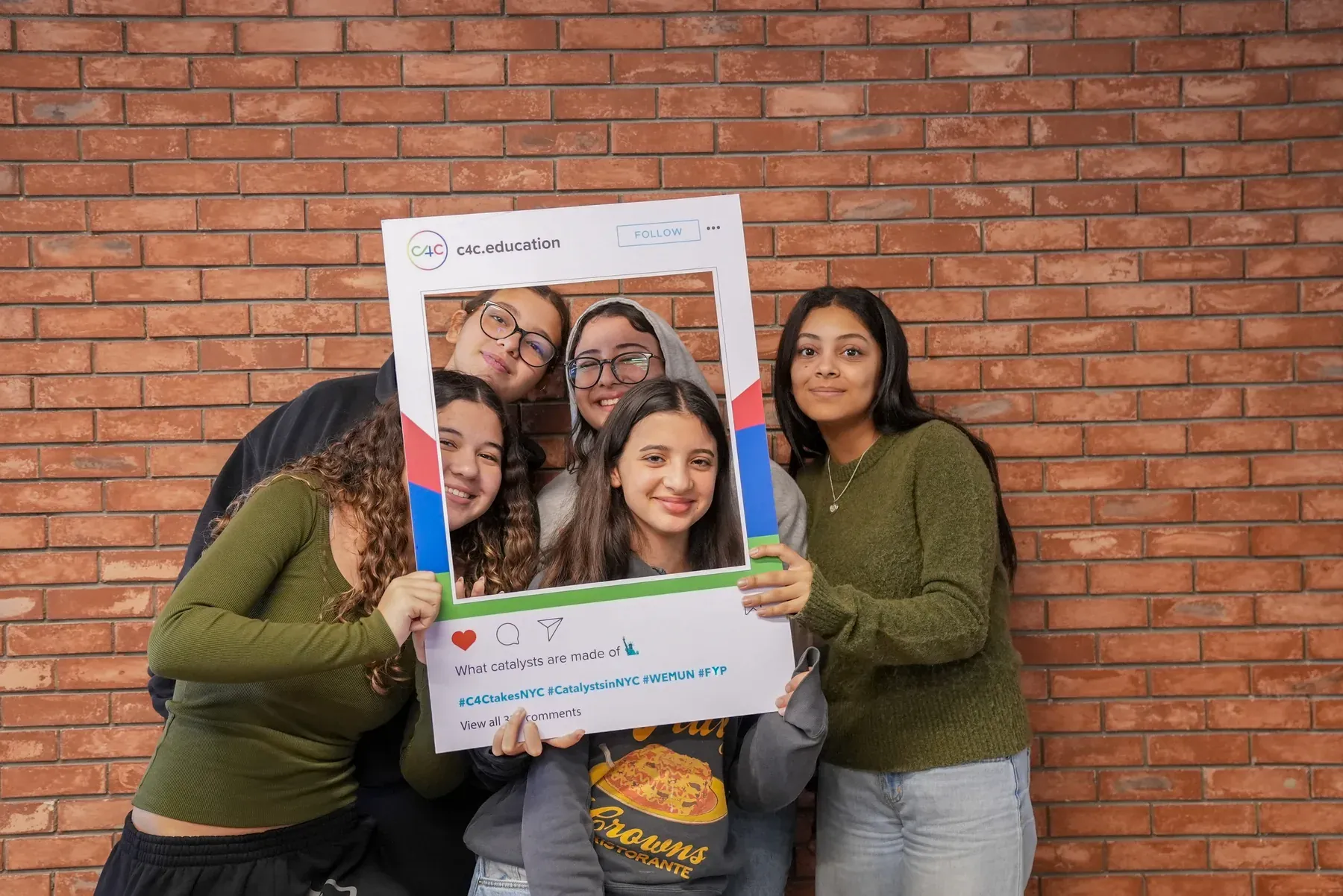 C4C students holding a C4C community photo frame together